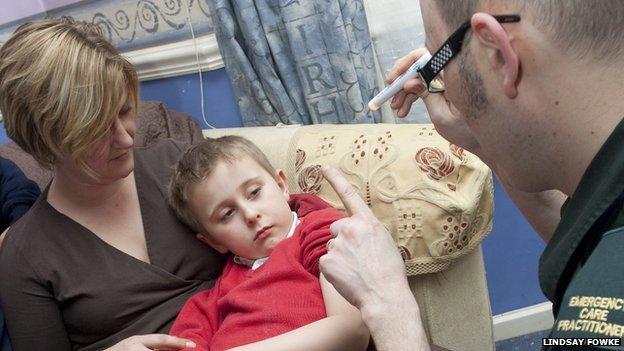 Paramedic treating child at home