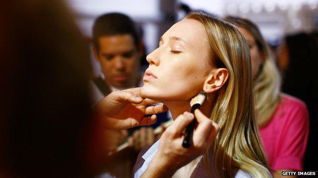 A model has her makeup done during Sao Paulo Fashion Week Winter 2015