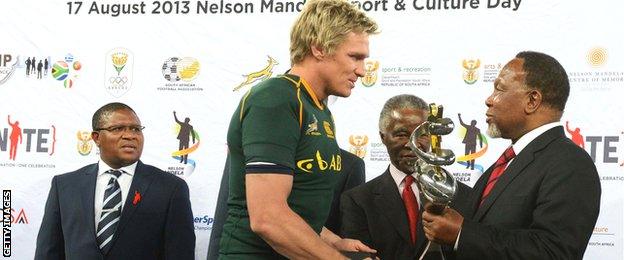 Boks captain Jean de Villiers receives a trophy from former South Africa president Thabo Mbeki and then deputy president Kgalema Motlanthe after victory over Argentina in Soweto in August 2013