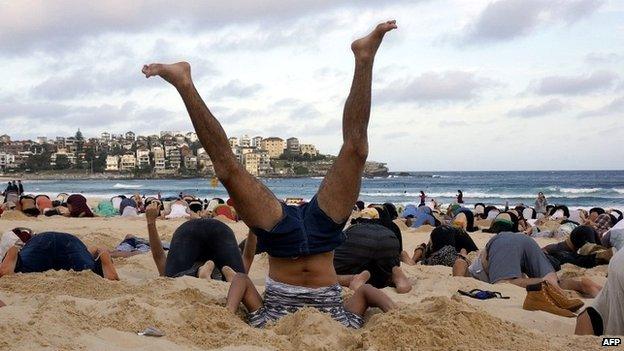 Australians bury their heads in Bondi Beach in a demonstration over climate change - 13 November 2014