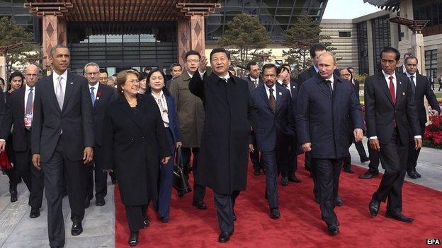 A handout picture released by Xinhua shows Chinese President Xi Jinping walk to plant trees with other leaders and representatives from the Asia-Pacific Economic Cooperation to mark friendship in the APEC family in Beijing, China on 11 November 2014