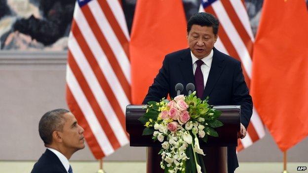 US President Barack Obama listens as Chinese President Xi Jinping speaks at a lunch banquet in the Great Hall of the People in Beijing on 12 November, 2014