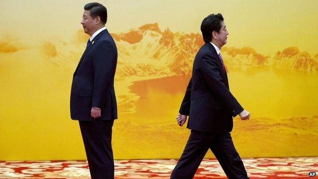 Japanese Prime Minister Shinzo Abe walks past China's Xi Jinping during a welcome ceremony for the APEC summit at the International Convention Center in Yanqi Lake, Beijing, China on 11 November, 2014