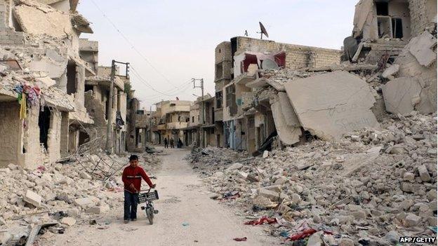 A Syrian boy walks with his bicycle in the devastated Sukari district in the northern city of Aleppo on 13 November 2014