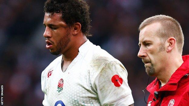 A member of the England medical team escorts Courtney Lawes from the pitch after he sustained a blow to the head in the defeat by New Zealand