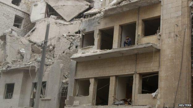 A boy looks out from a building damaged by what activists said was shelling by forces loyal to Syria's President Bashar al-Assad in Kalasa neighbourhood in Aleppo on 13 November 2014