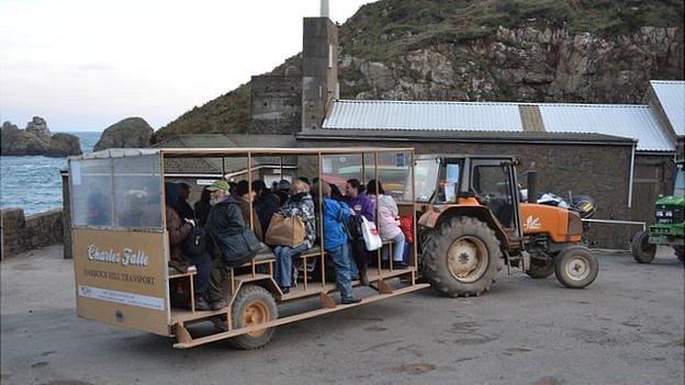 People getting the 'toast rack' or tractor trailer taxi up the Sark harbour hill