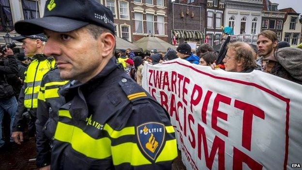 Dutch police form a line around a protest against Black Pete, Gouda, The Netherlands, 15 November 2014