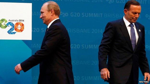 Australian Prime Minister Tony Abbott (R) reacts after officially welcoming Russian President Vladimir Putin to the G20 summit in Brisbane, Australia on 15 November 2014