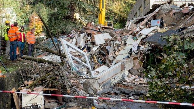 Rescue workers search the site where a landslide fell on a house killing two people in Davesco-Soragno near Lugano, Switzerland, on 16 November 2014