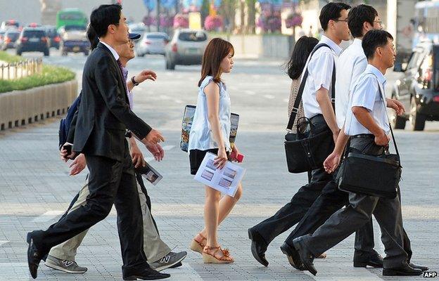 Korean office workers cross a road in Seoul