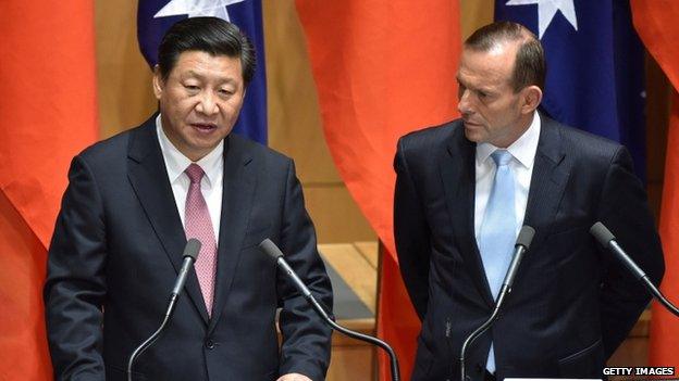 China's President Xi Jinping (L) and Australia's Prime Minister Tony Abbott (R) make statements to the media following the signing of a free trade agreement at Parliament House in Canberra on November 17, 2014