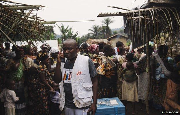 Doctor Adolph Batundi Bindu speaks on a satellite telephone from a vaccination site in the village of Kishee