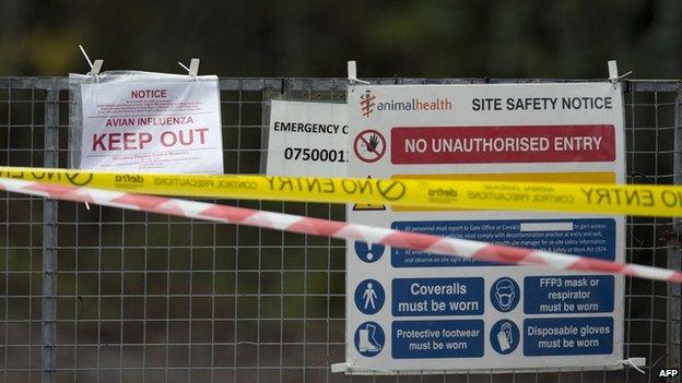 Signs are pictured attached to a gate at the entrance to a duck breeding farm where a case of bird flu has been identified in Nafferton, in Yorkshire