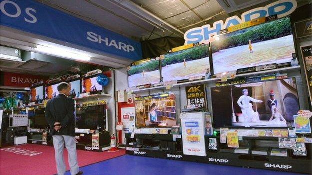 A customer looks at a television at an electronics stores in Tokyo on July 4, 2014