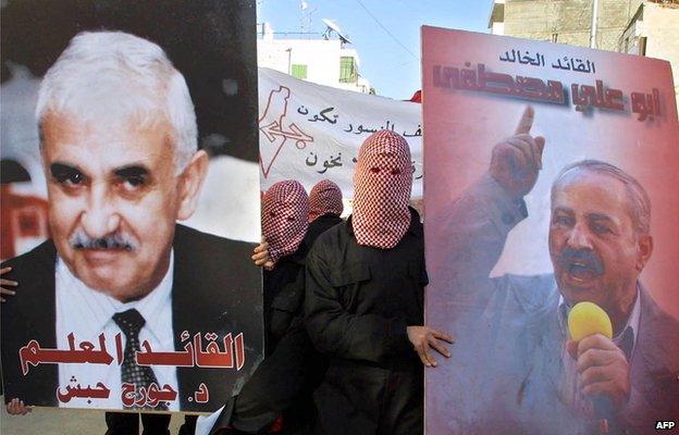 PFLP supporters hold up posters of George Habash (left) and Abu Ali Mustafa (right) in Ramallah in December 2001