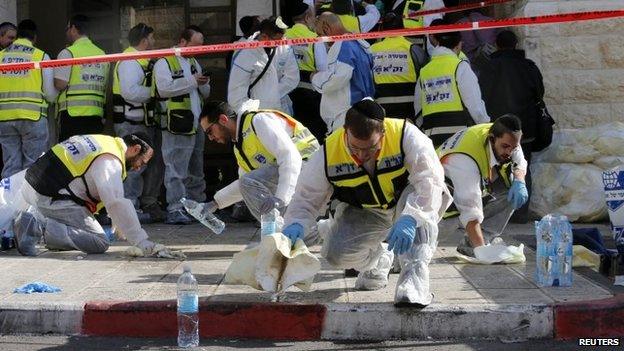 Members of the Israeli Zaka emergency response team clean blood from the scene of an attack at a Jerusalem synagogue on 18 November 2014