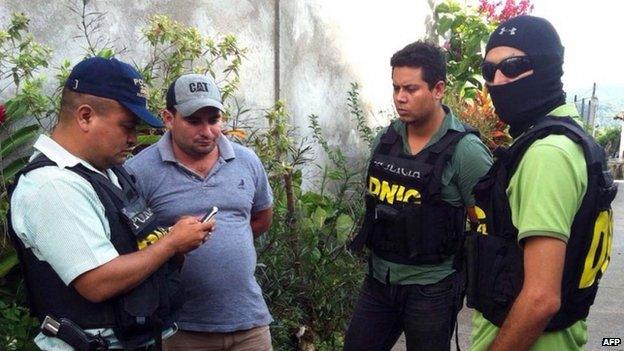 Police officers (in bullet-proof jackets) escort Plutarco Ruiz in Santa Barbara, Honduras, 18 November