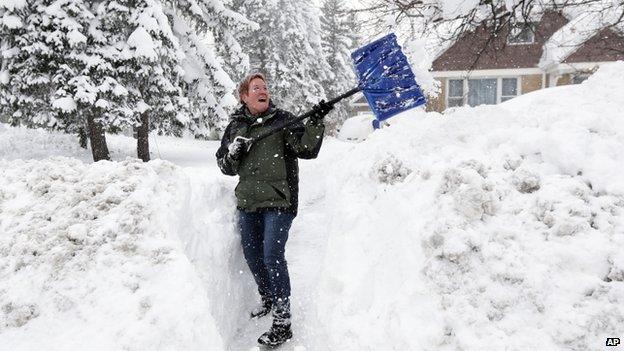 Sue Radka helps shovel out a friends driveway on in Lancaster, N.Y.