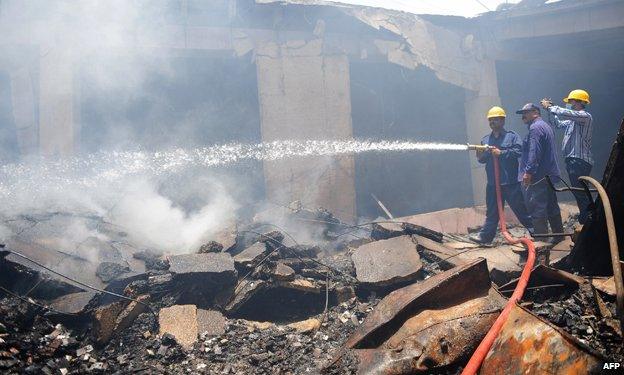 Fire fighters at the smouldering cold-storage facility at the Jinnah International Airport, Karachi, June 2014