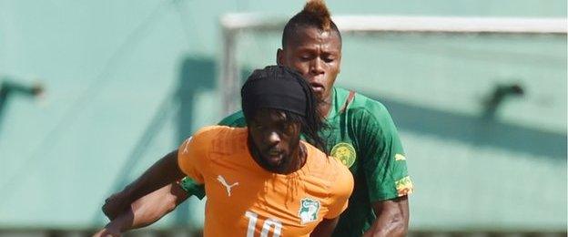 Ivory Coast's Gervinho (front) tussles with Cameroon's Clinton Ndjie