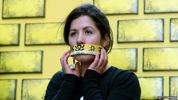 An Amnesty International activist covers her mouth as part of a campaign to end internet censorship in China