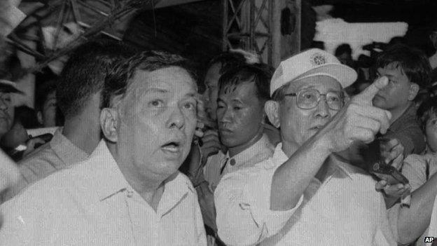 Philippine President Fidel Ramos, right, points to the collapsed ceiling of the Ozone Disco house which collapsed at the height of the fire that killed more than 150 people Tuesday, March 19, 1996