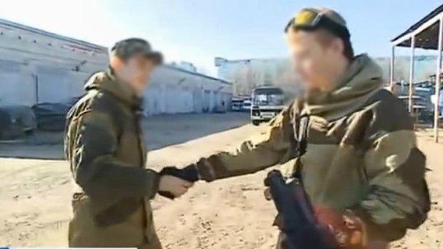 Two young men in uniform shaking hands, their faces blurred out