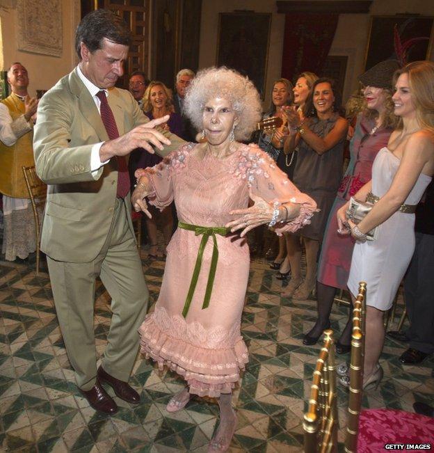 Spain's Duchess of Alba Cayetana Fitz-James Stuart y Silva (R) dances flamenco beside her husband Alfonso Diez outside Las Duenas Palace after their wedding in Seville in this October 5, 2011 file photo.