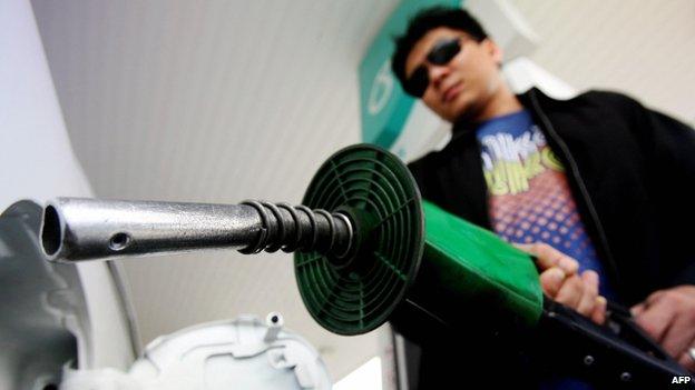 A man replaces a petrol pump at a Petronas station