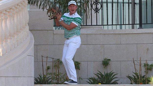 Jamie Donaldson holds the cat aloft