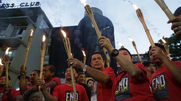 Journalists in Manila carry torches ahead of commemorations of the Maguindanao massacre. Photo: 21 November 2014