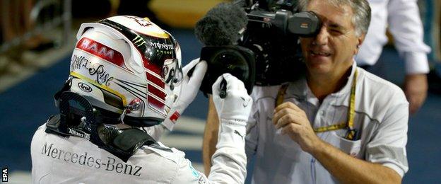 Lewis Hamilton signs the lens after winning the 2014 Drivers Championship