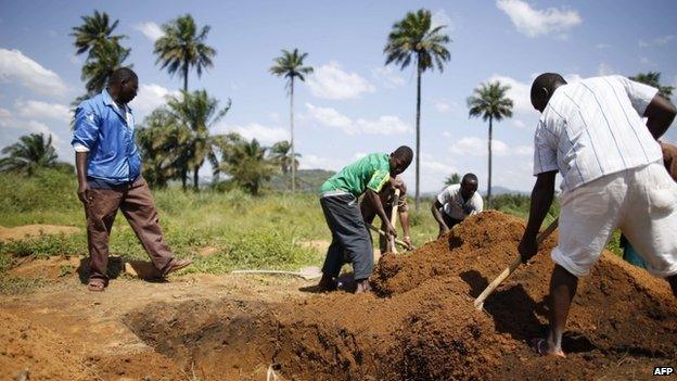 Health workers prepare to bury bodies of Ebola victims in Macenta, Guinea. Photo: 21 November 2014