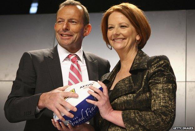 Opposition Leader Tony Abbott and Prime Minister Julia Gillard pose for photos during the North Melbourne AFL Grand Final Breakfast at Etihad Stadium on 1 October 2011 in Melbourne, Australia