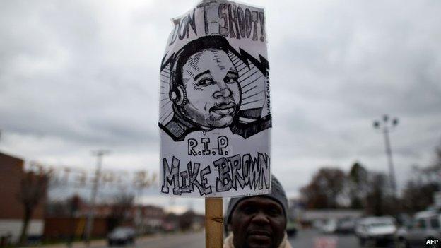 A protester displays a placard depicting 18-year-old Michael Brown on 24 November 2014