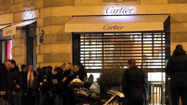 Police officers stand in front of a Cartier jewelery store on the Champs-Elysees avenue in Paris, where a robbery took place on November 25, 2014