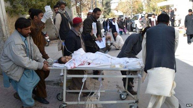 Pakistani volunteers shift an injured polio female health worker at a hospital in Quetta on November 26, 2014.