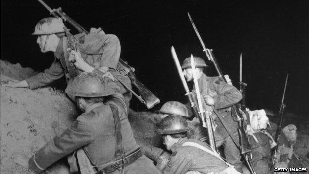 Soldiers climb over a ridge with bayonets at the ready in 1915