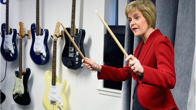 First Minister of Scotland Nicola Sturgeon, holds up drum sticks during a visit to The Kabin community learning centre