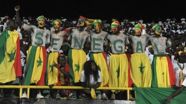 Supporters of the Senegal national football team celebrate on 5 September 2014 on the steps of the Leopold Sedar Senghor Stadium in Dakar where Senegal beat Egypt 2-0