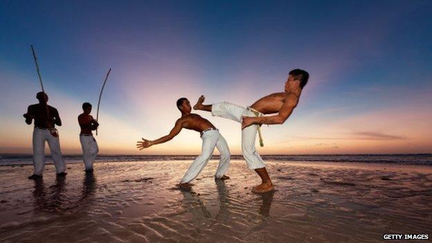 Capoeira dancers on a beach in Brazil