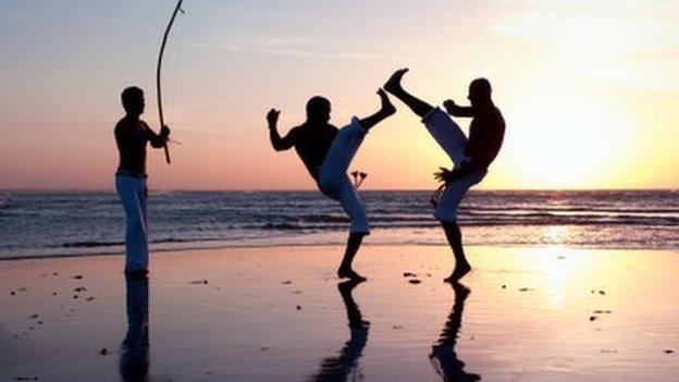 Capoeira dancers on a beach in Brazil