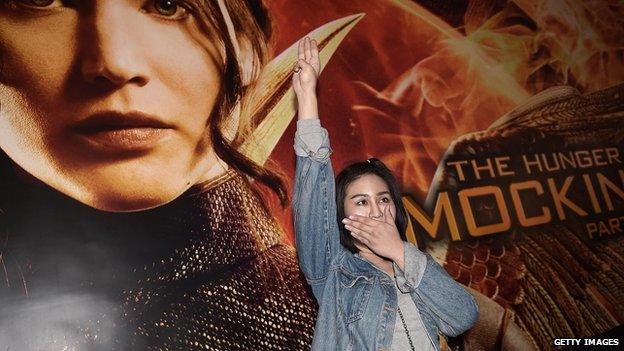 A protestor displays a Hunger Games-inspired salute.