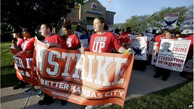 Protesters march outside a Taco Bell restaurant in Kansas City, Mo. on Thursday, Sept. 4, 2014, as part of the "Fight for $15" campaign, a national protest to push fast-food chains to pay their employees at least $15 an hour