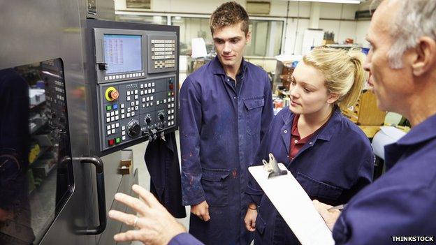 Apprentices learning how to use a computerised lathe