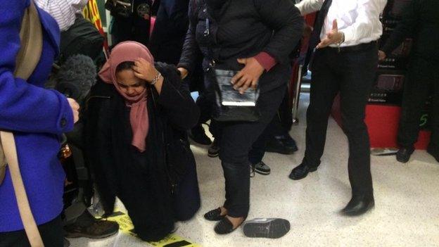 A woman on her knees, having fallen over in a supermarket