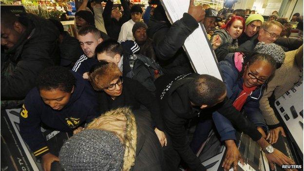 Shoppers compete to purchase retail items on "Black Friday" at an Asda superstore in Wembley