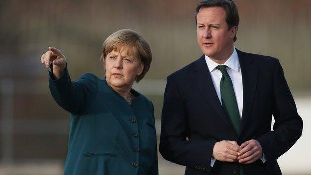 British Prime Minister David Cameron speaks with German Chancellor Angela Merkel during a stroll in the garden following his arrival at Schloss Meseberg government guest house on April 12, 2013