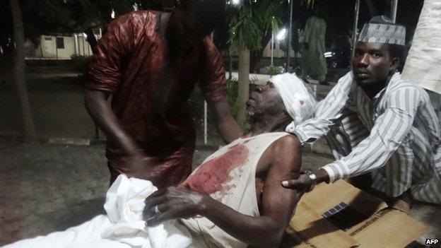 People assist an injured man in Kano. Photo: 28 November 2014